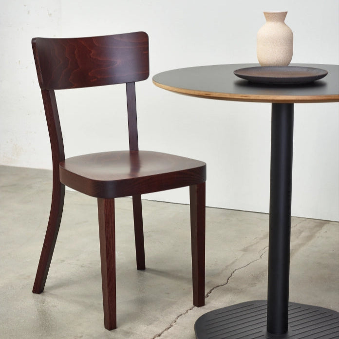 Dunkelbrauner Holzstuhl im klassischen Beizenstil neben rundem Bistrotisch mit Vase schlichtes Design für Restaurant oder Esszimmer